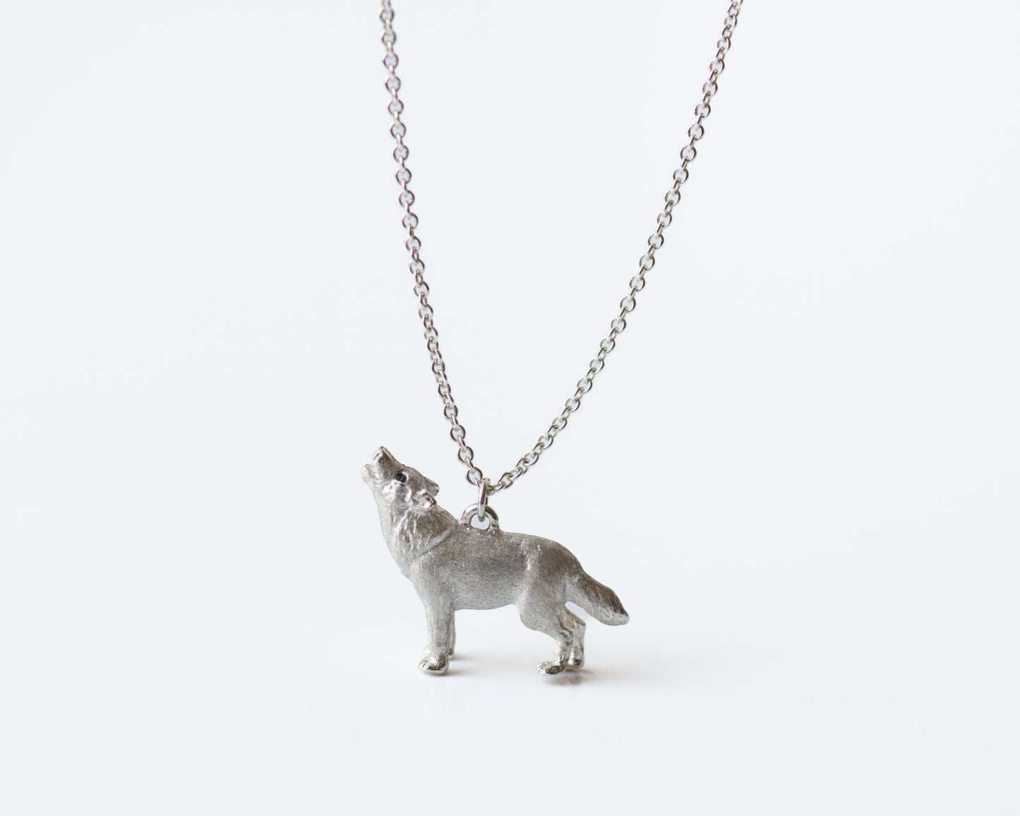 Silver wolf pendant necklace on a white background