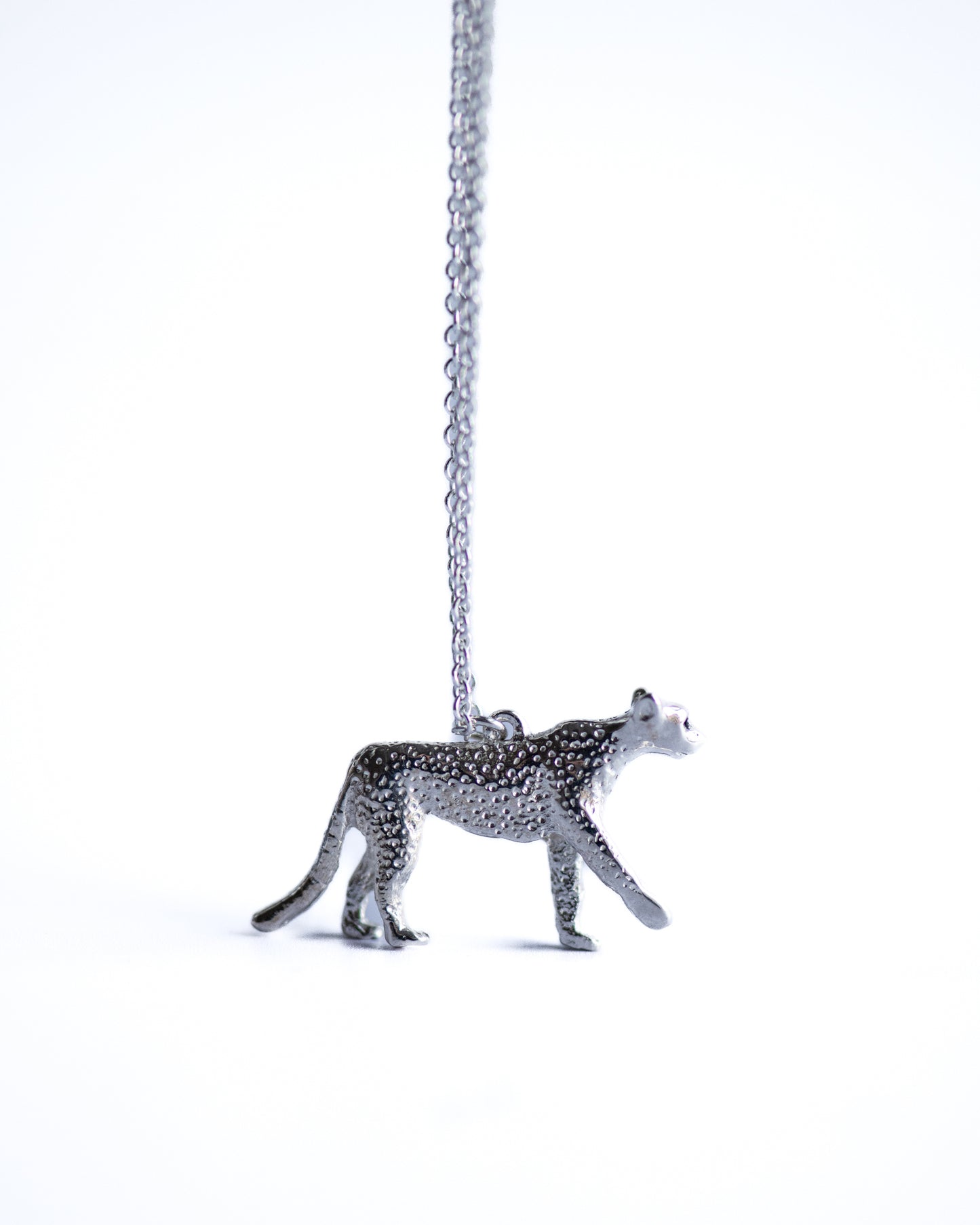 Silver cheetah pendant on a chain against a white background