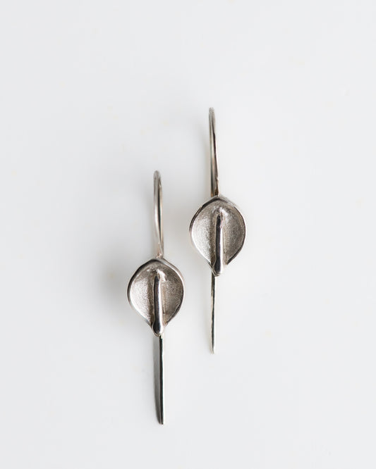 Hand carved calla lily silver earrings on a white background