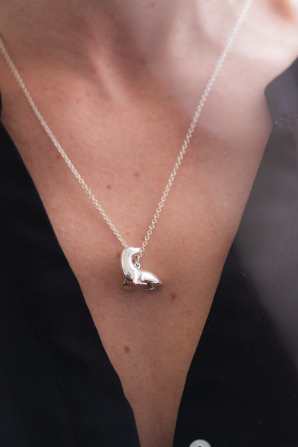 Silver necklace with a seal sea lion pendant worn by a person  Rutheny wildlife anatomically accurate